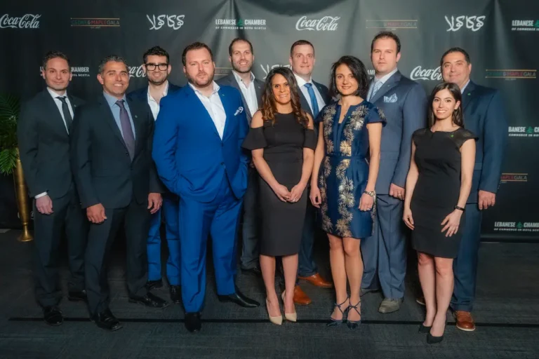Group corporate gala photo booth portrait featuring a custom dark branded backdrop by Moments in Time Photography Studio