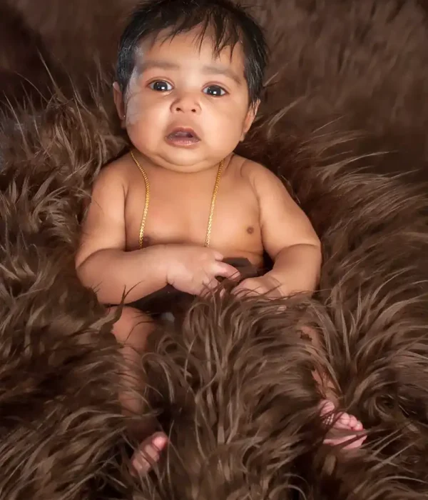 Halifax newborn photographer portrait of a baby sitting on a brown faux fur blanket in studio