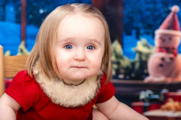 Christmas mini portrait sessions Halifax Nova Scotia 3 Blue-eyed toddler girl in a red dress with a fur collar beside a snowman decoration, Halifax Christmas portrait