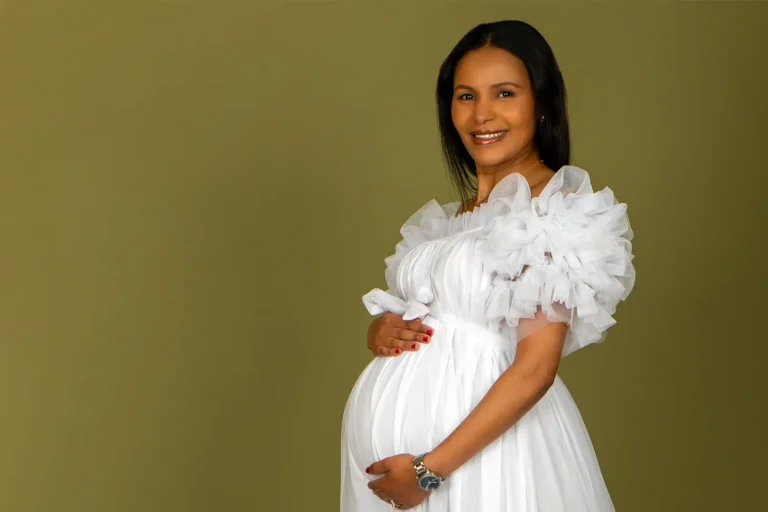 Maternity Portraits 3 Pregnant woman in a white ruffled gown smiling on an olive green studio backdrop, Halifax maternity photographer