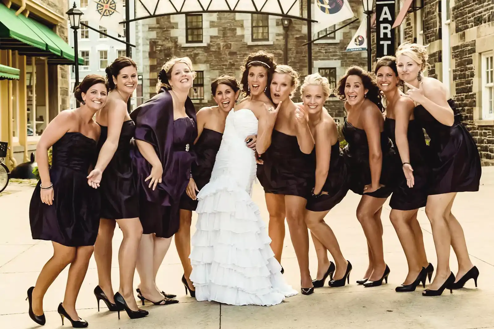 Wedding Photography 5 Bride laughing with her bridesmaids in dark purple dresses on a cobblestone street at Historic Properties, Halifax wedding photography