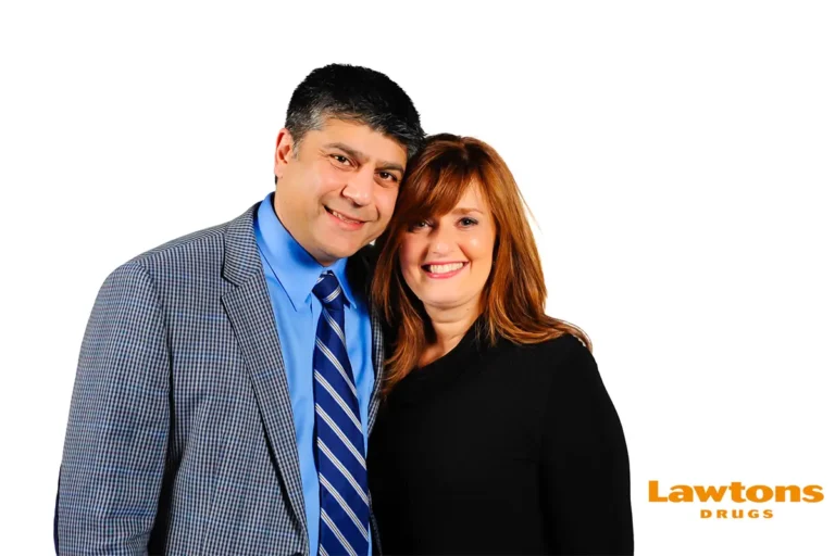 Couple smiling together at a Lawtons corporate event photo booth on a white backdrop by Moments in Time Photography Studio